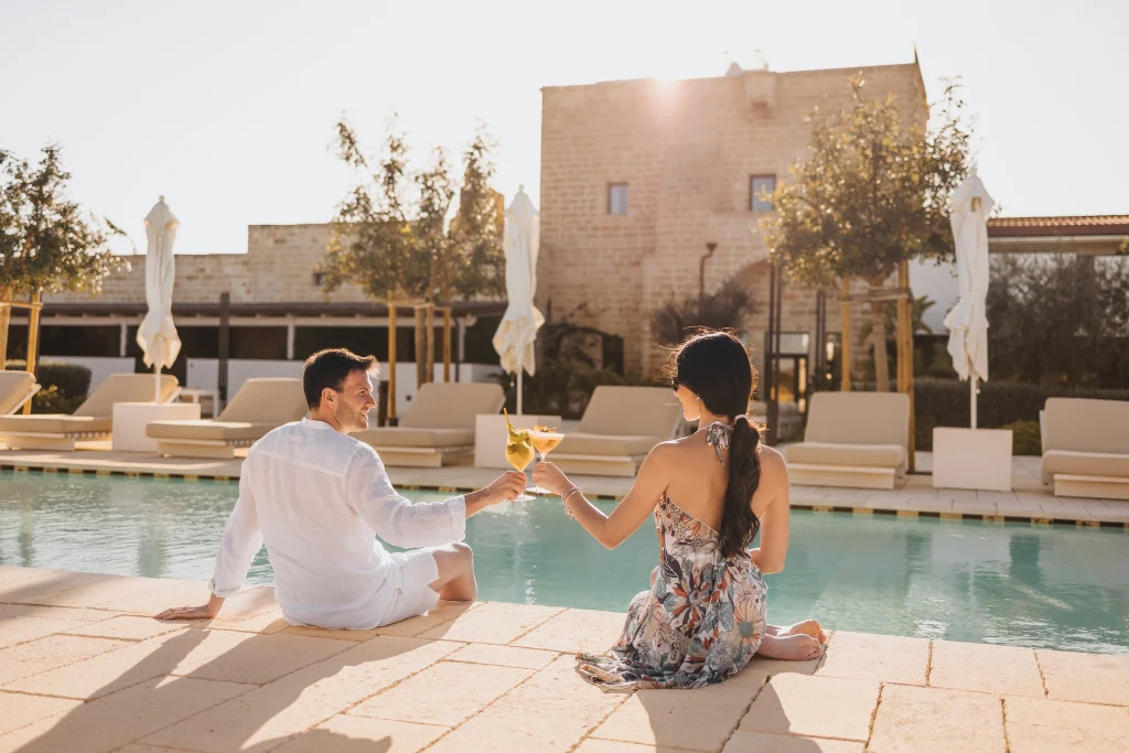 Coppia a bordo piscina al tramonto