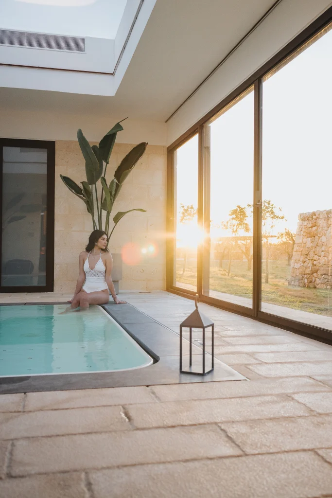 Piscina interna con vetrate al tramonto
