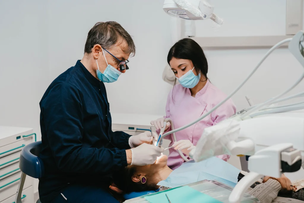 Odontoiatra e assistente al lavoro con un paziente